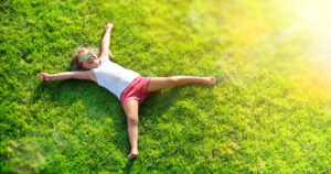 Smiling Little Girl Lying On Grass Meadow Smiling Little Girl Lying On Grass Meadow